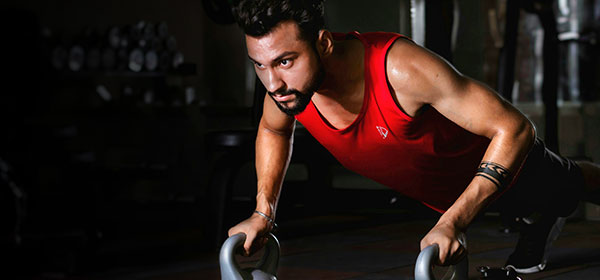 Man doing push-ups with kettlebells at gym