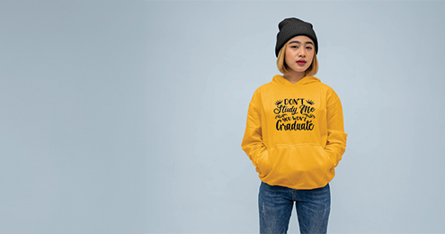 Woman in yellow hoodie and black beanie against blue background